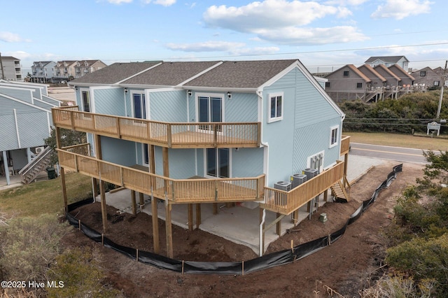 back of house with a wooden deck, a balcony, and central AC unit