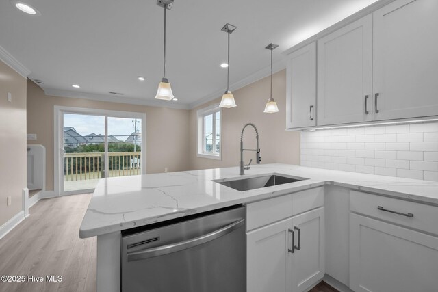 kitchen featuring stainless steel dishwasher, white cabinetry, sink, and tasteful backsplash