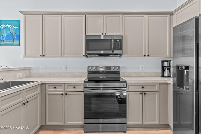 kitchen with sink, gray cabinetry, and appliances with stainless steel finishes