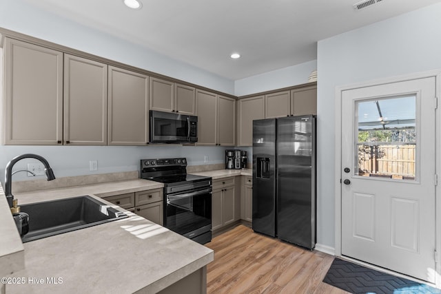 kitchen featuring light hardwood / wood-style floors, stainless steel refrigerator with ice dispenser, electric range, gray cabinetry, and sink