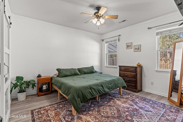 bedroom featuring ceiling fan, light wood-type flooring, and ornamental molding