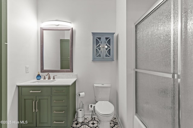 full bathroom featuring toilet, tile patterned floors, vanity, and bath / shower combo with glass door