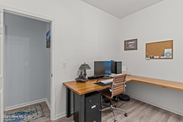 home office with light hardwood / wood-style floors