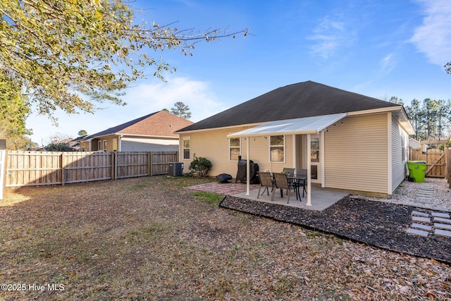 back of property with central AC unit and a patio