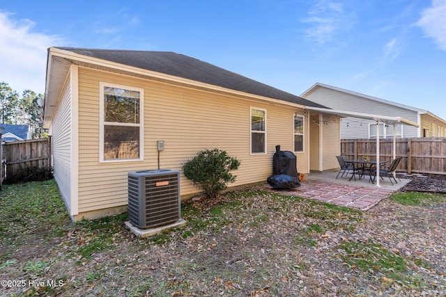 rear view of property featuring a patio and central AC