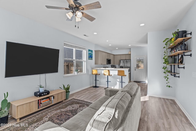 living room featuring light hardwood / wood-style floors and ceiling fan