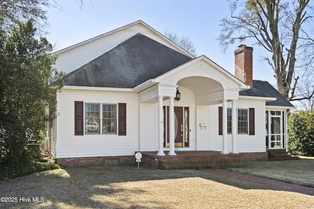 view of front of house featuring crawl space, a chimney, a front lawn, and roof with shingles