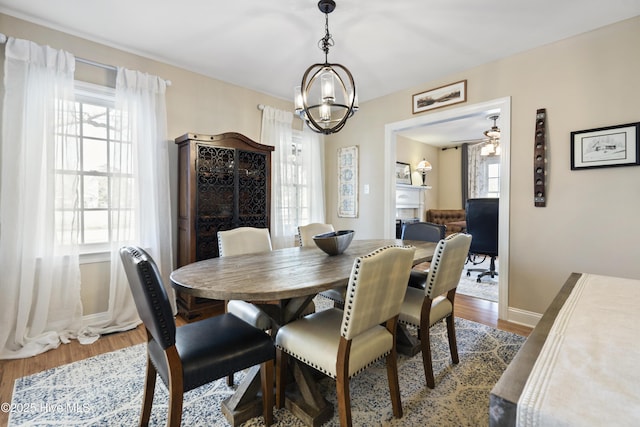 dining space with wood finished floors, a wealth of natural light, and baseboards