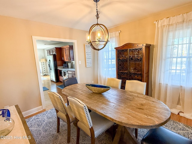 dining area with wood-type flooring and a notable chandelier