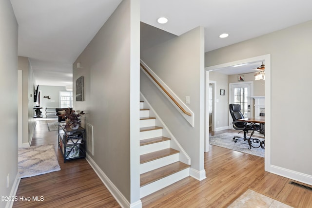 stairs featuring hardwood / wood-style flooring and a wealth of natural light