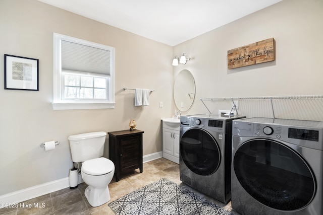 laundry room featuring laundry area, washing machine and dryer, baseboards, and a sink