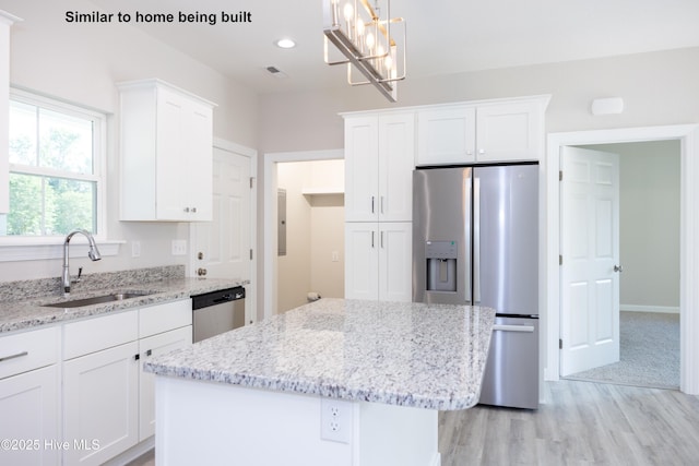 kitchen with pendant lighting, sink, white cabinetry, and appliances with stainless steel finishes