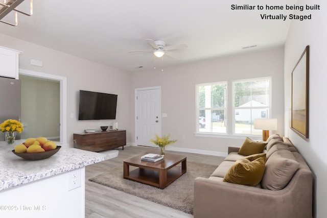 living room featuring ceiling fan and light hardwood / wood-style floors