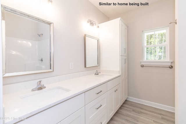 bathroom with a shower, wood-type flooring, and vanity