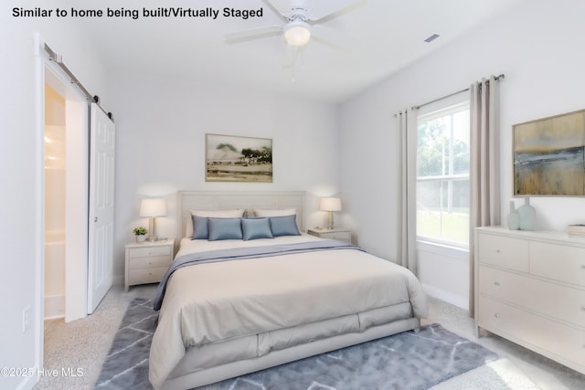 carpeted bedroom featuring ensuite bathroom, a barn door, and ceiling fan