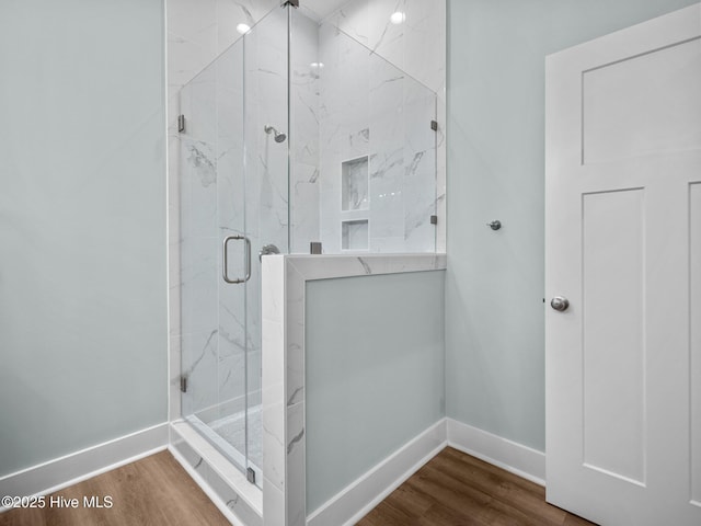 bathroom featuring a shower with door and hardwood / wood-style floors