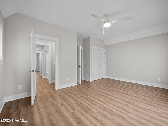 unfurnished bedroom with ceiling fan, vaulted ceiling, and light wood-type flooring