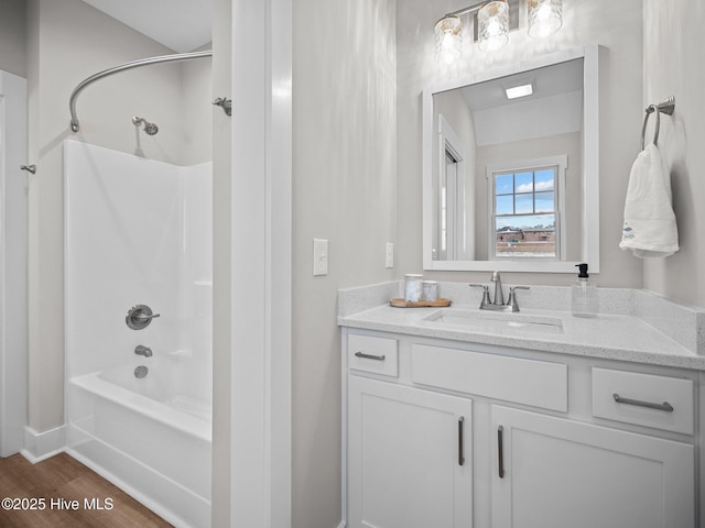 bathroom featuring hardwood / wood-style flooring, vanity, and tub / shower combination