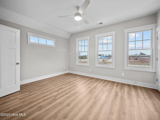 empty room with light wood-type flooring, ceiling fan, and lofted ceiling