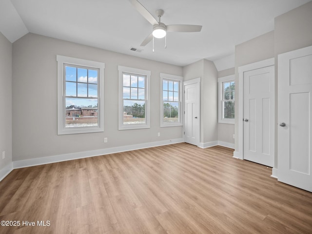 unfurnished bedroom with ceiling fan, light hardwood / wood-style floors, lofted ceiling, and multiple windows