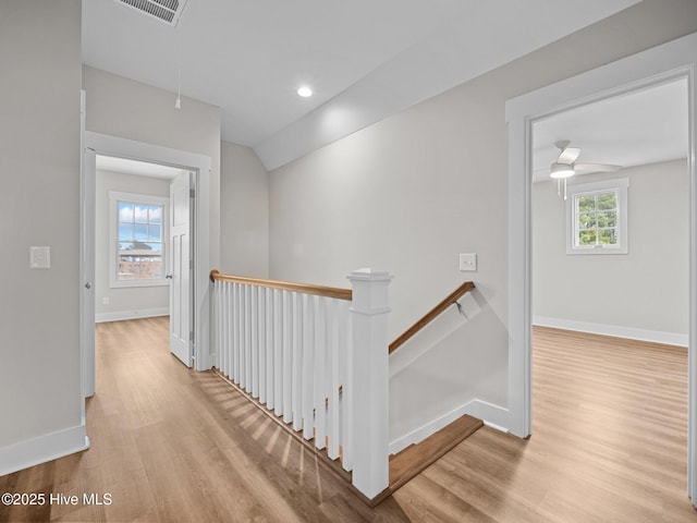 hallway with light hardwood / wood-style flooring and vaulted ceiling