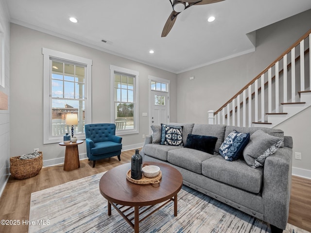 living room with wood-type flooring, ceiling fan, and ornamental molding