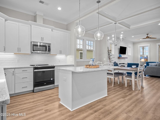 kitchen featuring white cabinets, hanging light fixtures, ceiling fan, a kitchen island, and stainless steel appliances