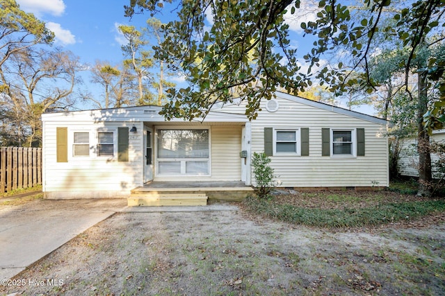 view of front of property with crawl space and fence