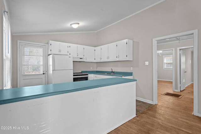 kitchen featuring electric stove, freestanding refrigerator, white cabinetry, vaulted ceiling, and under cabinet range hood