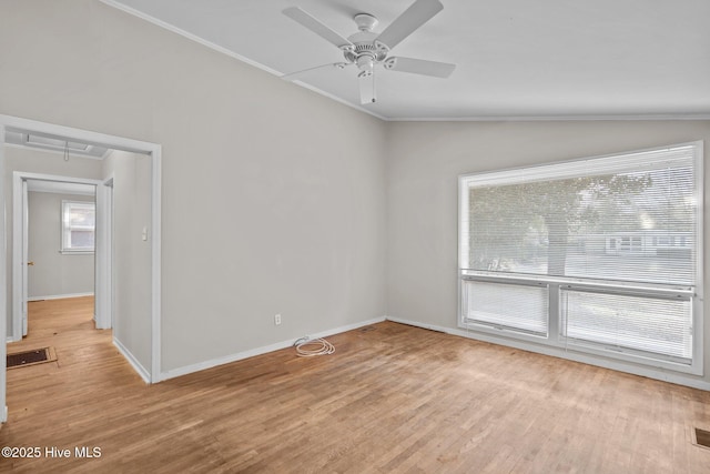 spare room featuring lofted ceiling, baseboards, ornamental molding, light wood finished floors, and attic access