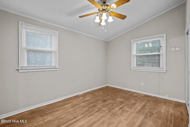 unfurnished room featuring ornamental molding, vaulted ceiling, baseboards, and wood finished floors