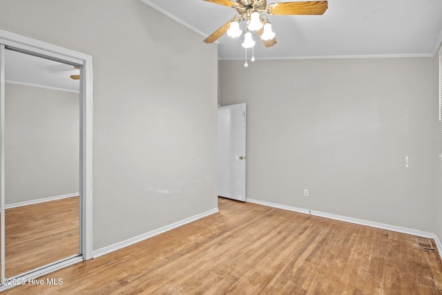 unfurnished bedroom with baseboards, light wood finished floors, visible vents, and crown molding