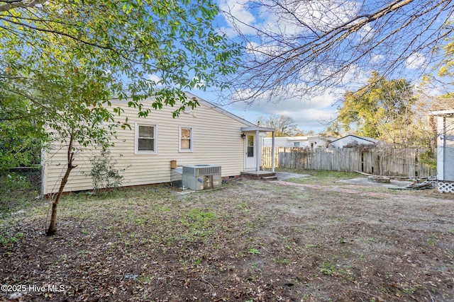 back of house with central AC and fence