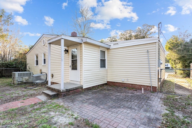 rear view of property featuring a chimney, fence, cooling unit, and a patio