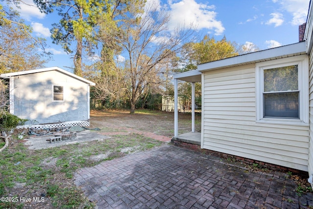 view of yard featuring an outbuilding, a storage shed, and a patio area