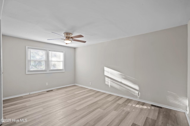 unfurnished room featuring a ceiling fan, light wood-type flooring, visible vents, and baseboards