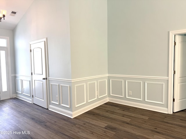 657 Boundary Loop NW, Carolina Shores, NC 28467 - entrance foyer with dark wood-type flooring, a wainscoted wall, vaulted ceiling, and a decorative wall