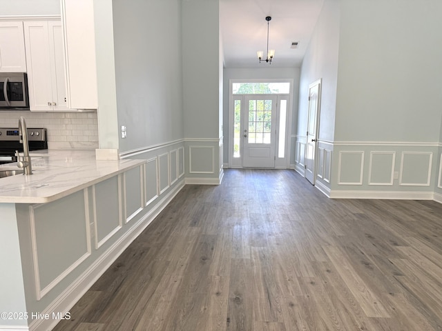 657 Boundary Loop NW, Carolina Shores, NC 28467 - entrance foyer featuring a decorative wall, dark wood-type flooring, and a wainscoted wall