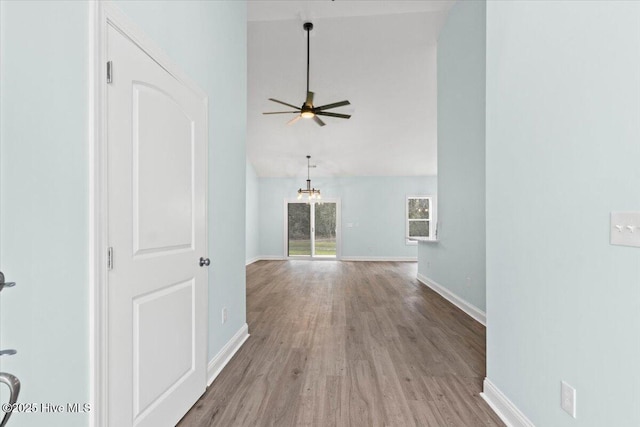 657 Boundary Loop NW, Carolina Shores, NC 28467 - unfurnished room with wood finished floors, baseboards, ceiling fan, high vaulted ceiling, and a chandelier