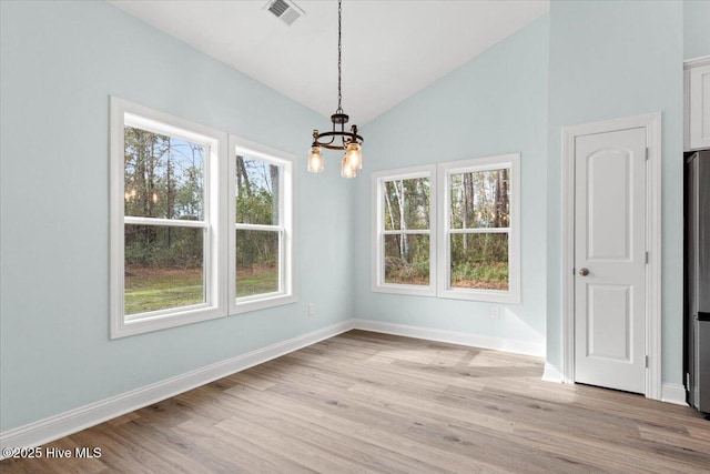 657 Boundary Loop NW, Carolina Shores, NC 28467 - unfurnished dining area featuring a chandelier, vaulted ceiling, light wood finished floors, and baseboards