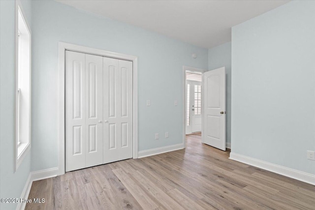 unfurnished bedroom featuring light hardwood / wood-style flooring and a closet