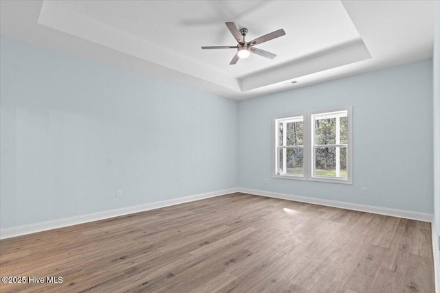 657 Boundary Loop NW, Carolina Shores, NC 28467 - unfurnished room with a tray ceiling, wood finished floors, baseboards, and a ceiling fan