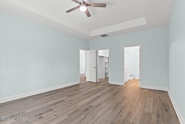 657 Boundary Loop NW, Carolina Shores, NC 28467 - unfurnished bedroom featuring light wood-style flooring, a walk in closet, baseboards, a closet, and connected bathroom