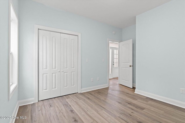 657 Boundary Loop NW, Carolina Shores, NC 28467 - unfurnished bedroom featuring wood finished floors, a closet, and baseboards