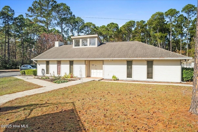 657 Boundary Loop NW, Carolina Shores, NC 28467 - view of front of property with a front lawn, a chimney, and roof with shingles