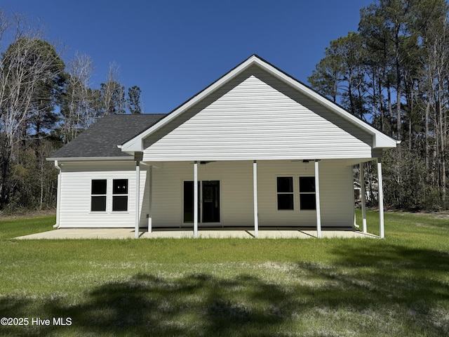 657 Boundary Loop NW, Carolina Shores, NC 28467 - rear view of property with a patio area, a lawn, and a shingled roof