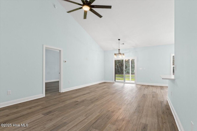 unfurnished living room with dark hardwood / wood-style flooring, ceiling fan with notable chandelier, and high vaulted ceiling