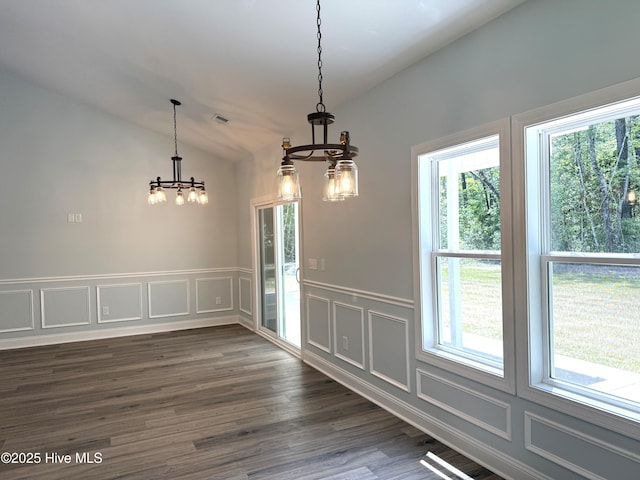 657 Boundary Loop NW, Carolina Shores, NC 28467 - unfurnished dining area featuring a chandelier, a decorative wall, healthy amount of natural light, lofted ceiling, and dark wood-style flooring