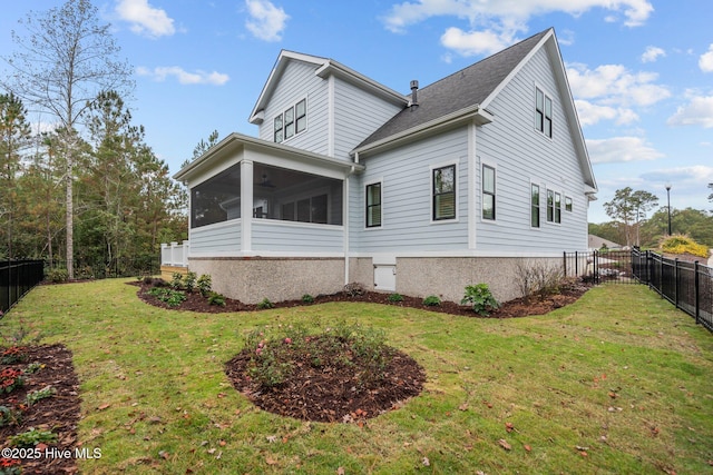 view of home's exterior with a sunroom and a yard