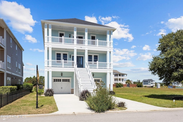 beach home featuring a front yard, covered porch, a garage, and a balcony